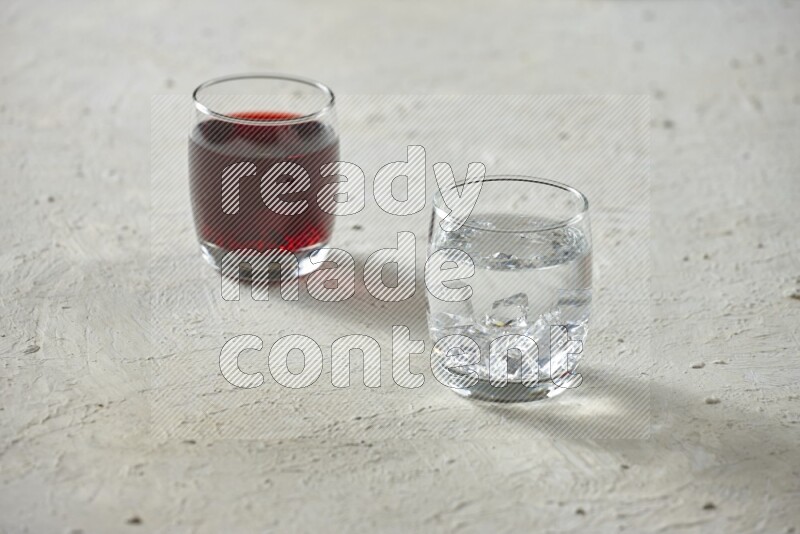 Cold drinks in a glass cup such as water, tamarind, qamar eldin, sobia, milk and hibiscus on textured white background
