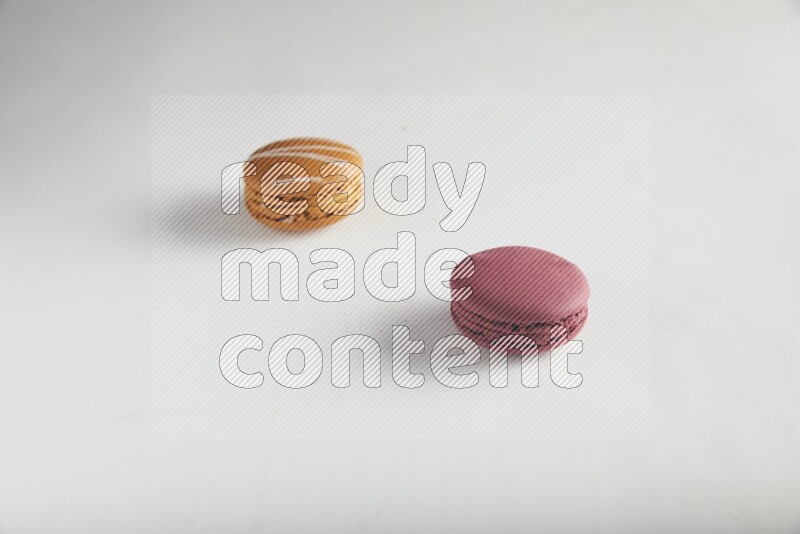 45º Shot of of two assorted Brown Irish Cream, and Red Cherry macarons on white background