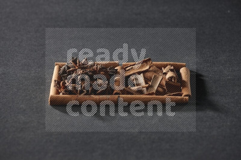 2 squares of cinnamon sticks full of star anise and cinnamon on black flooring