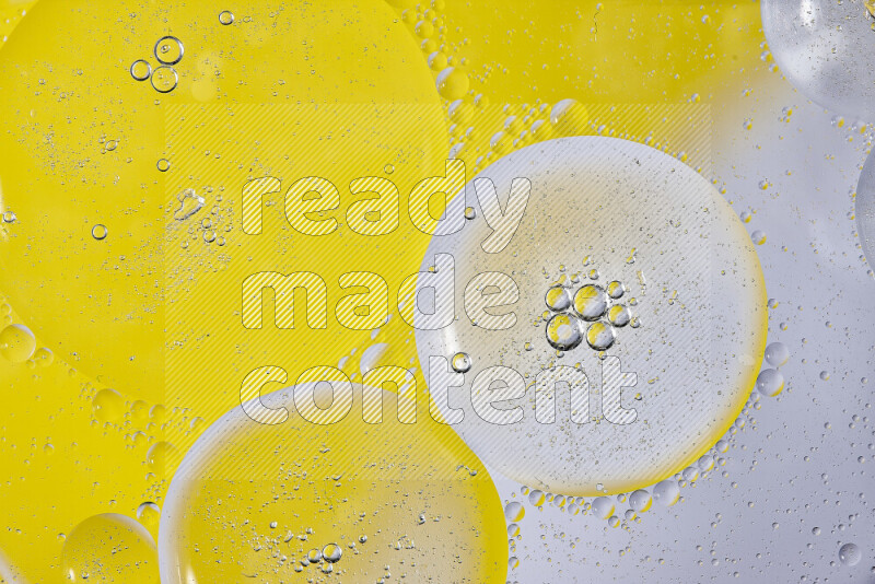 Close-ups of abstract oil bubbles on water surface in shades of white and yellow
