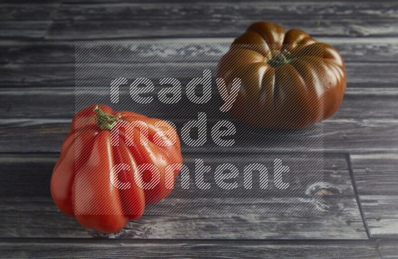 45 degree two heirloom tomato on a textured grey wooden background