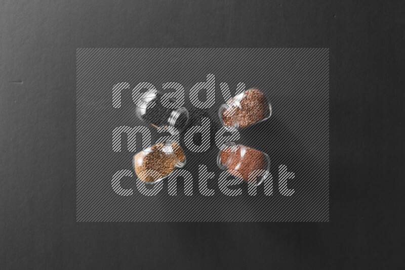 حبة البركة و حبوب الخردل وحبوب الكتان وحب الرشاد في أوعية زجاجية علي خلفية سوداء