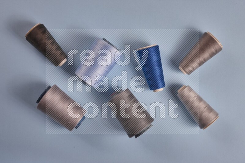 A grey collection of sewing and tailoring tools arranged on a blue background