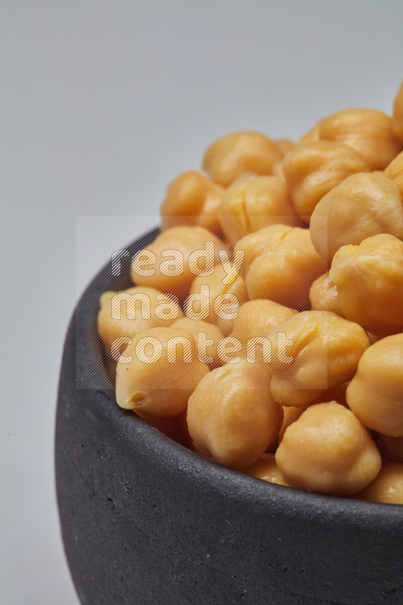 Close up shot of boiled chickpeas in a container on white background