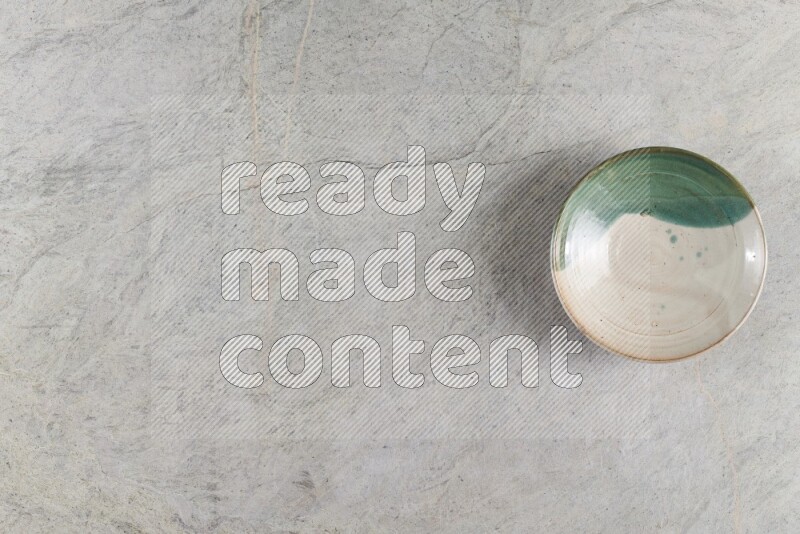 A decorative pottery plate on grey marble background