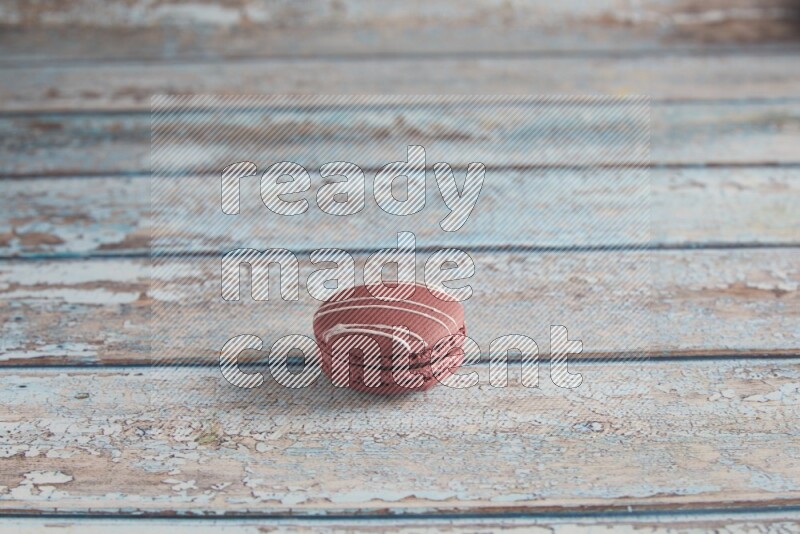 45º Shot of Red Poppy Flower macaron on light blue wooden background