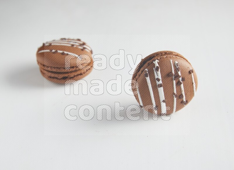 45º Shot of two Brown white Chocolate Caramel macarons on white background