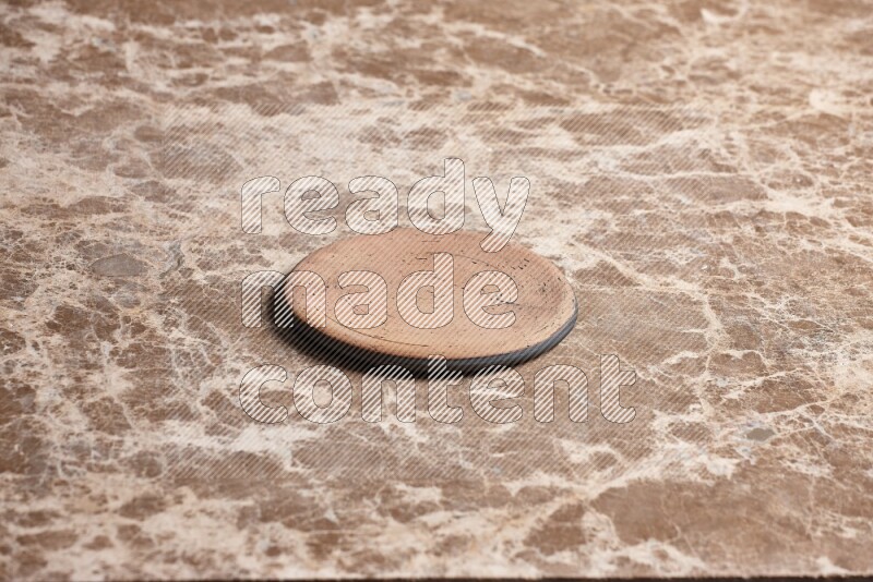A pottery coaster on beige marble background