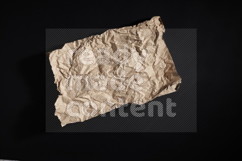 Crumpled craft paper on black background