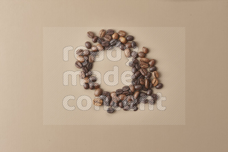 Roasted coffee beans on beige background