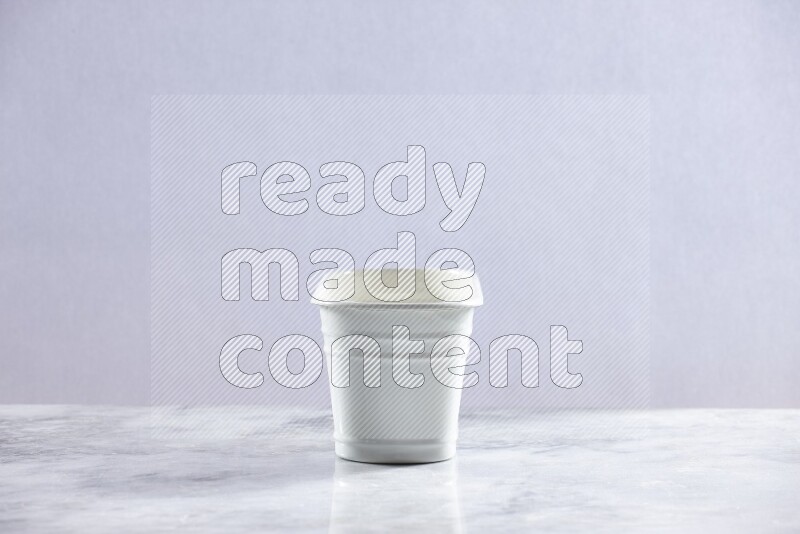 An empty white plant pot on grey marble background