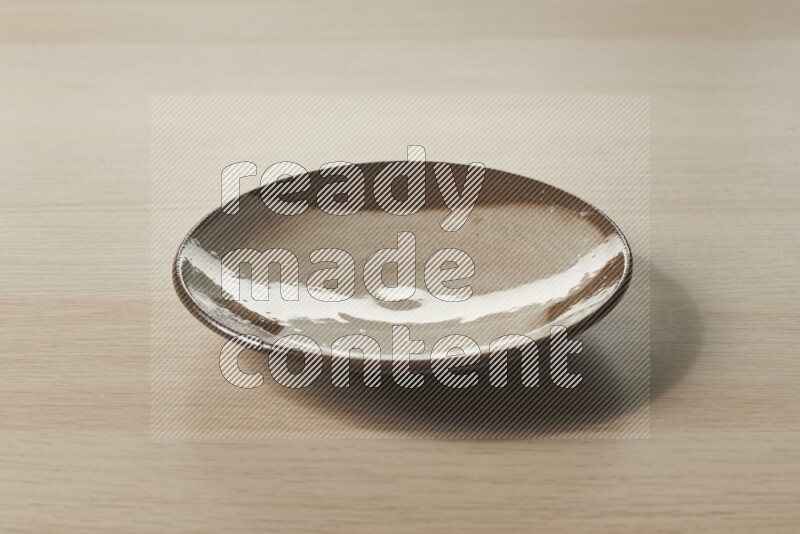 A multicolored pottery plate on light wooden background