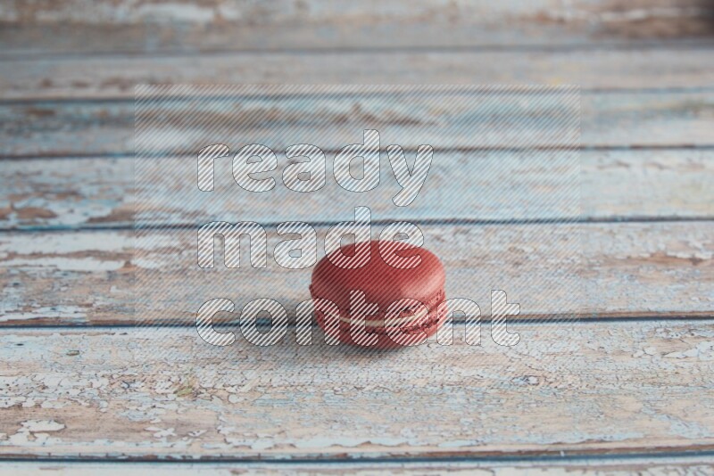 45º Shot of Red Velvet macaron on light blue wooden background