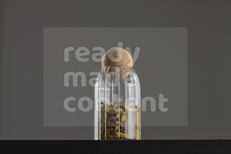 Turmeric in a glass jar on black background