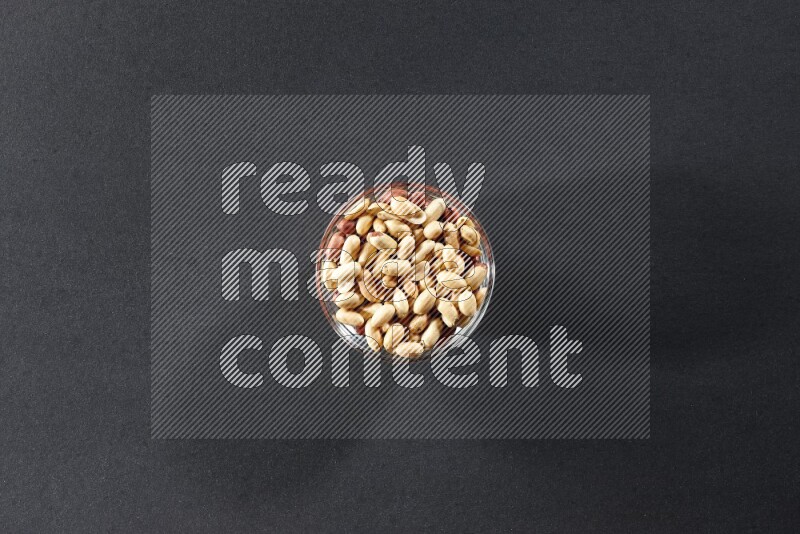 A glass bowl full of peeled peanuts on a black background in different angles
