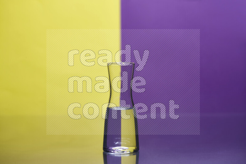The image features a clear glassware filled with water, set against yellow and purple background