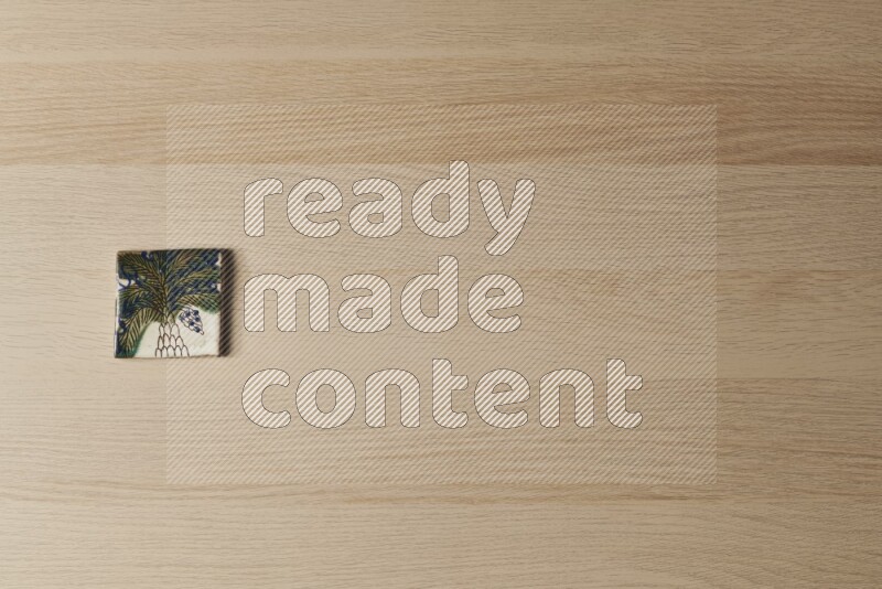 A decorative pottery coaster on light wooden background
