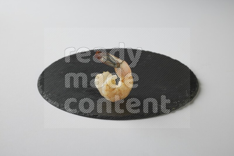 one  grilled shrimp  on a black slate direct  on a white back ground