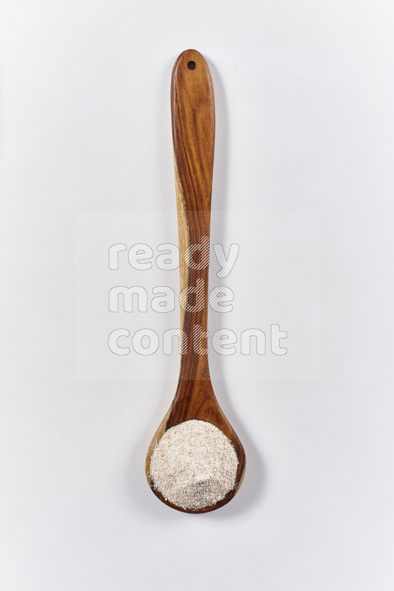 A wooden ladle full of onion powder on white background