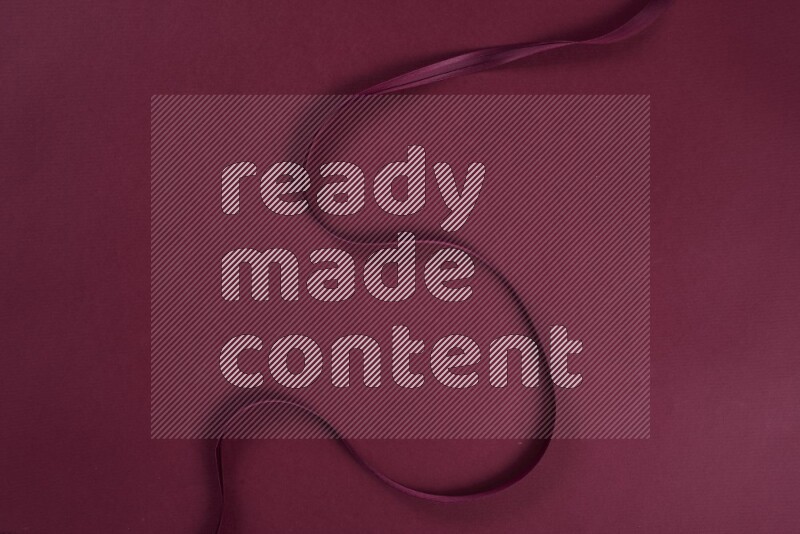 A red collection of sewing and tailoring tools arranged on a red background