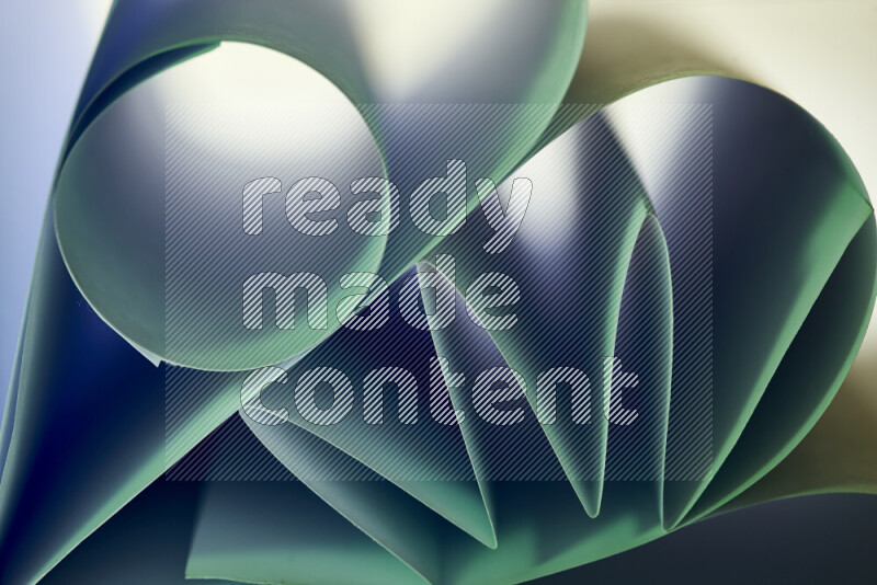 An artistic display of paper folds creating a harmonious blend of geometric shapes, highlighted by soft lighting in green tones
