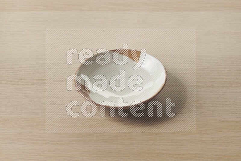 A multicolored pottery plate on light wooden background