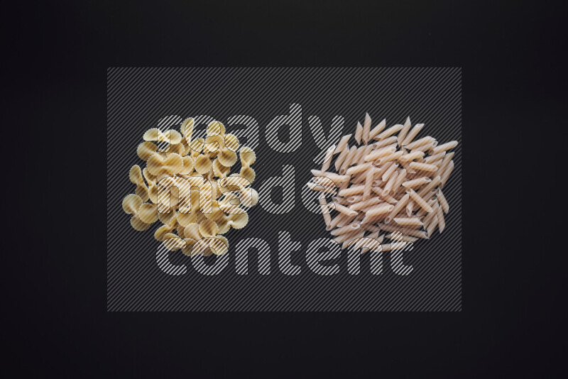 Different pasta types in bunches on black background