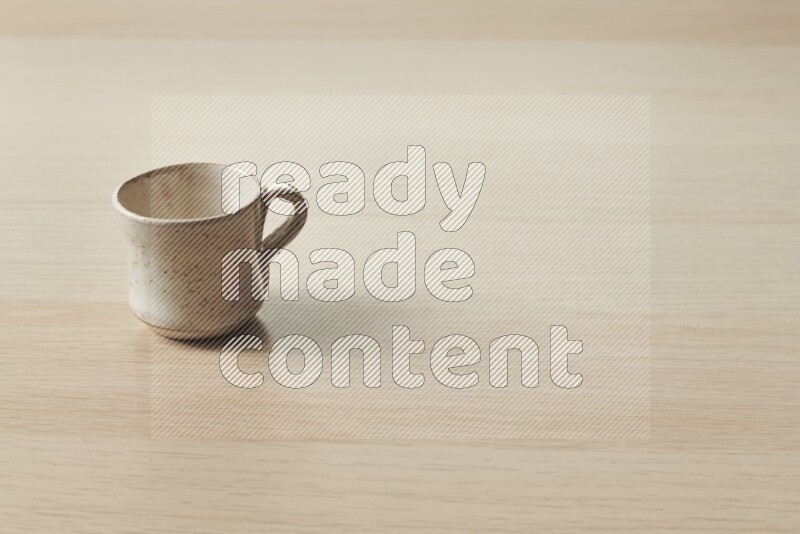 A pottery cup on light wooden background