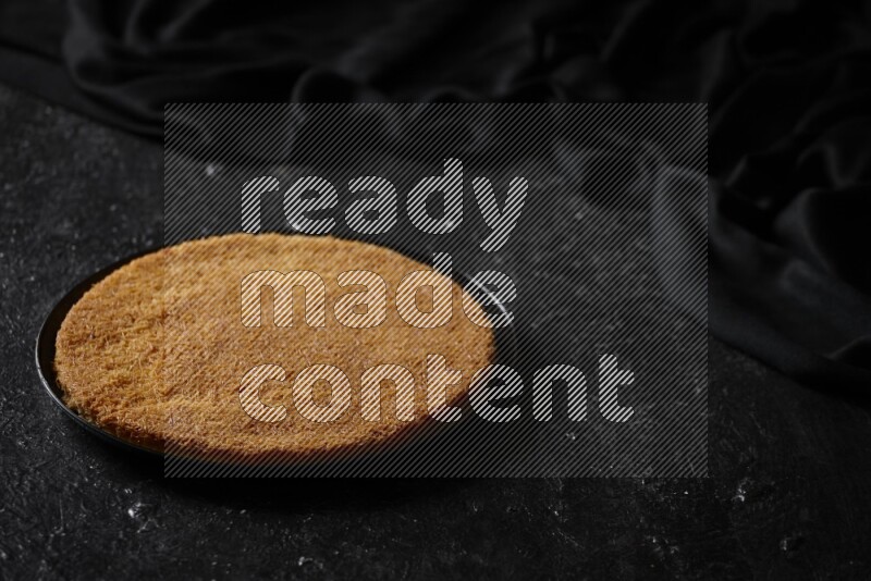 كنافة في أطباق مختلفه علي خلفية سوداء خشبية