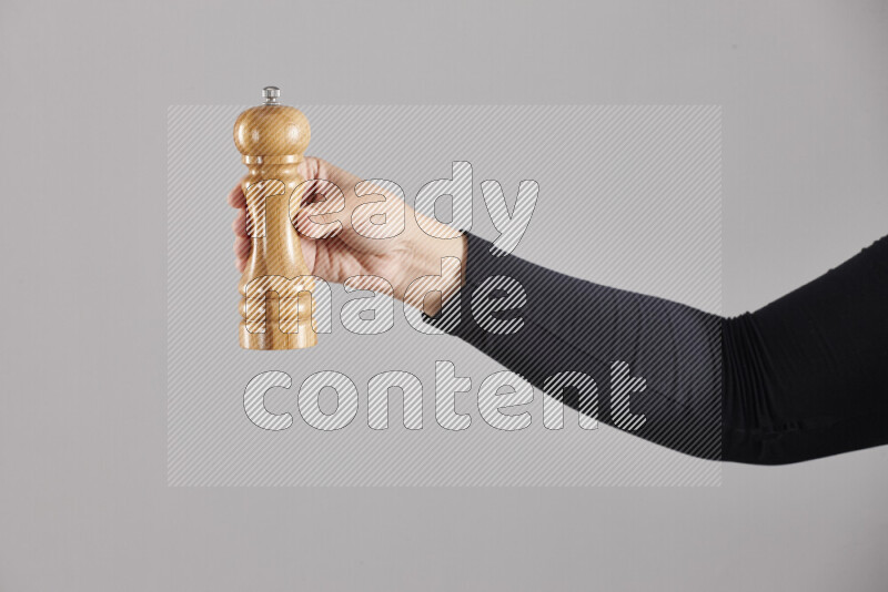 امرأة ترتدي عباءة سوداء تحمل أدوات خشبية مختلفة في أوضاع متعددة