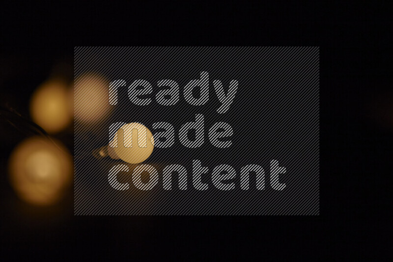 Light bulbs glowing against backdrop of golden bokeh