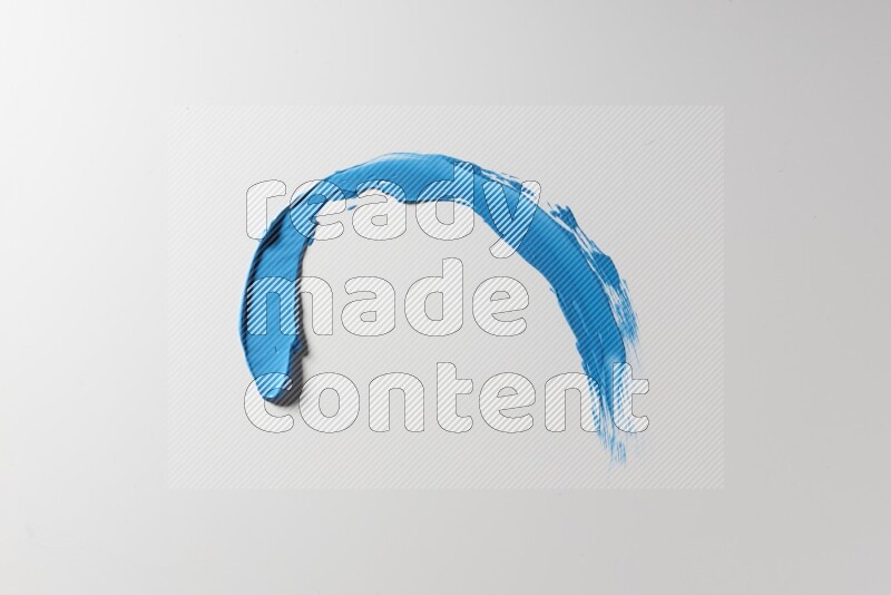 A blue single curved painting knife stroke on a white background