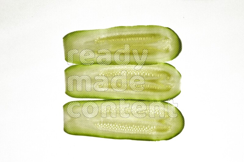Zucchini slices on illuminated white background
