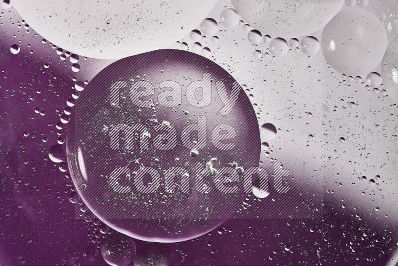 Close-ups of abstract oil bubbles on water surface in shades of white and purple