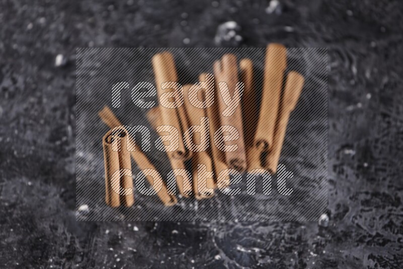 Cinnamon sticks on a textured black background