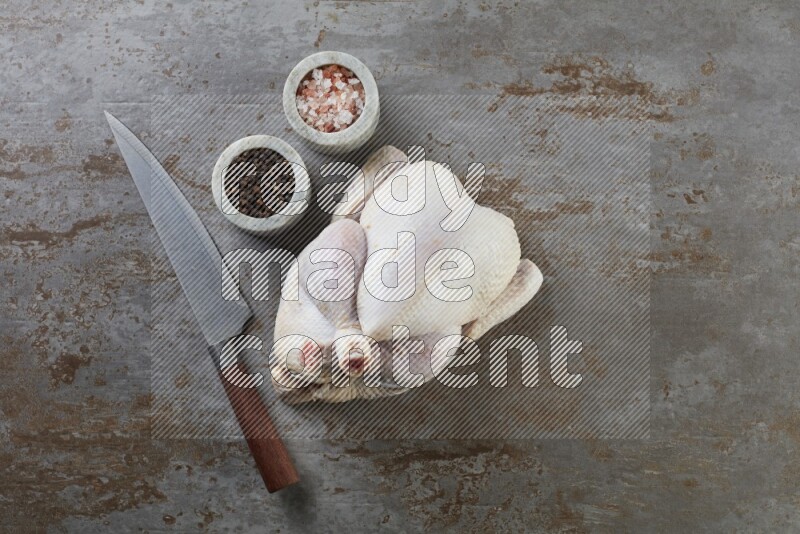 whole raw chicken  direct on a rustic grey background