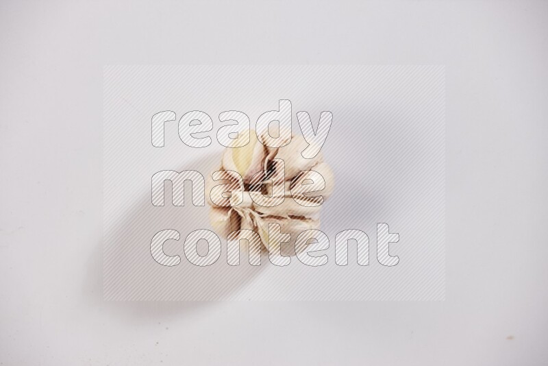 A whole garlic bulb placed on a white flooring