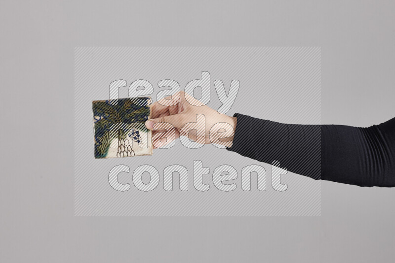 A woman in black abaya holding different pottery essentials in different positions