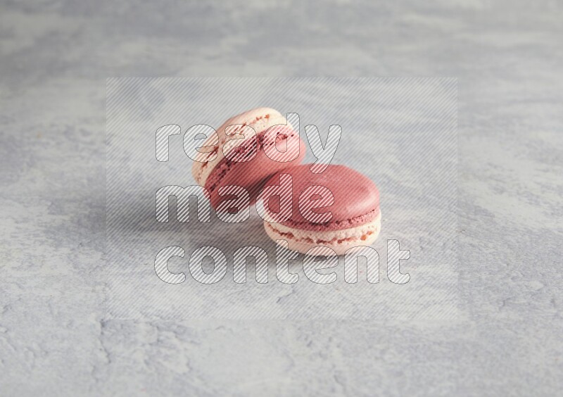45º Shot of two Pink Litchi Raspberry macarons  on white  marble background