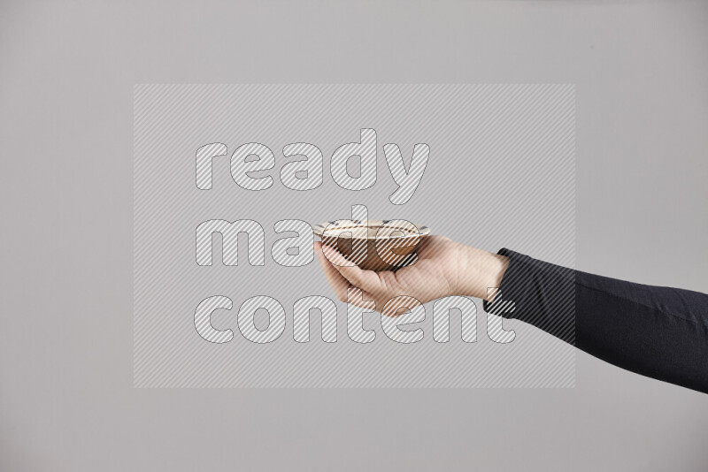 امرأة ترتدي عباءة سوداء تحمل أدوات فخارية مختلفة في أوضاع متعددة