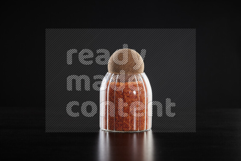 Lentils in a glass jar on black background