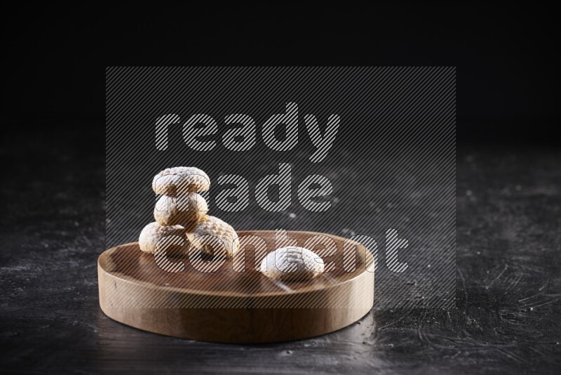 Kahk on a serving plate on a black background