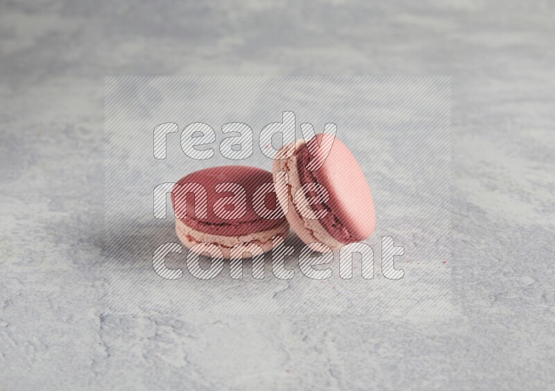 45º Shot of two Pink Litchi Raspberry macarons  on white  marble background