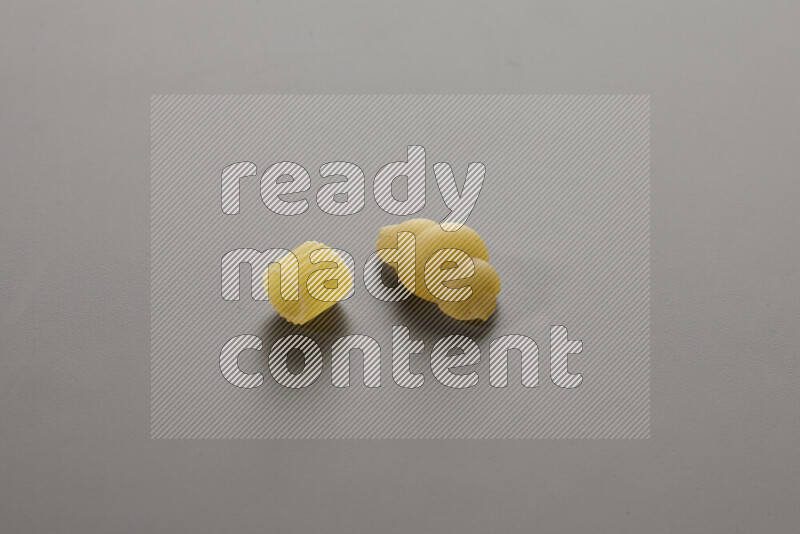 Big rings pasta with other types of pasta on grey background