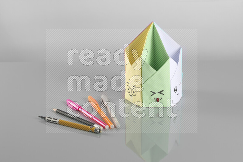 Origami pen holder on grey background