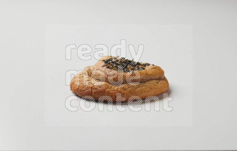 Hasawi cookie field with date and decorated by black seed and Anise grain on a white background