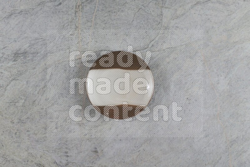 A multicolored pottery plate on grey marble background