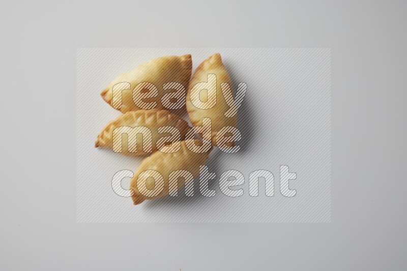 Four fried sambosa from a top angle on a white background