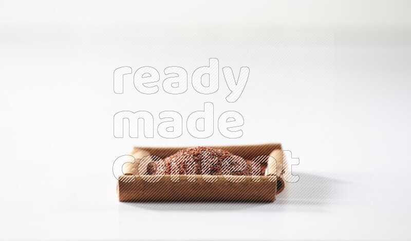 A single square of cinnamon sticks full of garden cress on white flooring