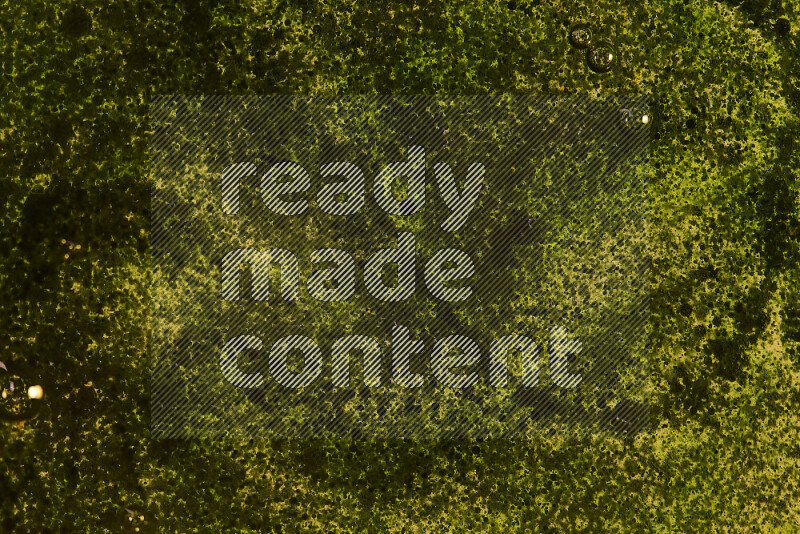 لقطات مقربة لقطرات ألوان مائية زرقاء على سطح الزيت على خلفية صفراء